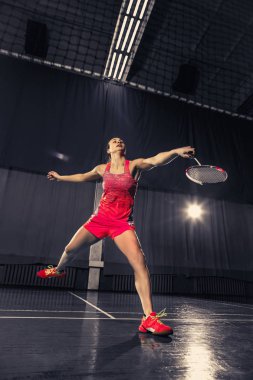 Genç kadın spor salonunda badminton oynarken
