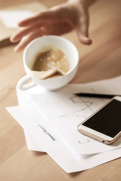 朝作業日のオフィスのテーブルでテーブルにこぼれる白いカップにコーヒー — ストック写真