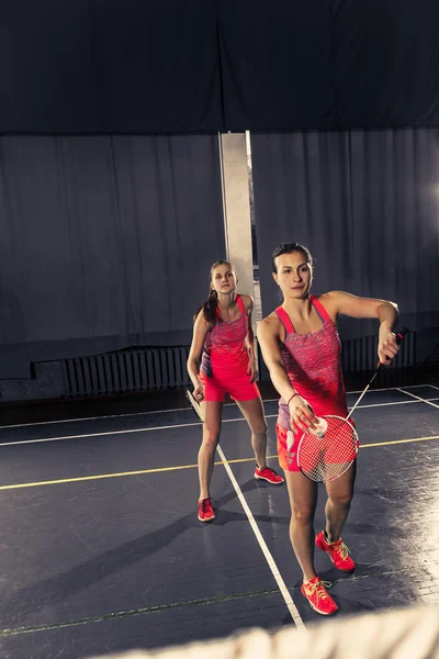 Unga kvinnor spelar badminton på gym — Stockfoto