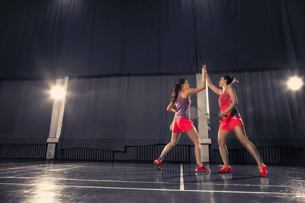 Unga kvinnor spelar badminton på gym — Stockfoto