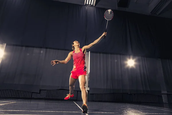 Ung kvinna spelar badminton på gym — Stockfoto