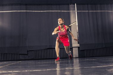 Genç kadın spor salonunda badminton oynarken