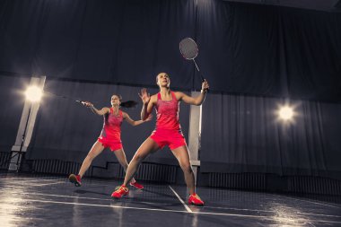 Genç kadın spor salonunda badminton oynarken