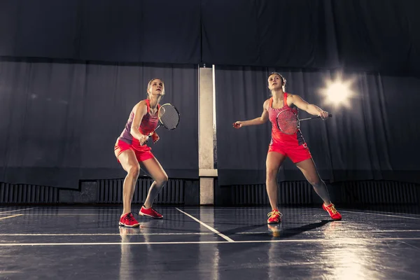 Mujeres jóvenes jugando al bádminton en el gimnasio —  Fotos de Stock