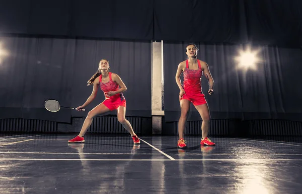 Mujeres jóvenes jugando al bádminton en el gimnasio —  Fotos de Stock