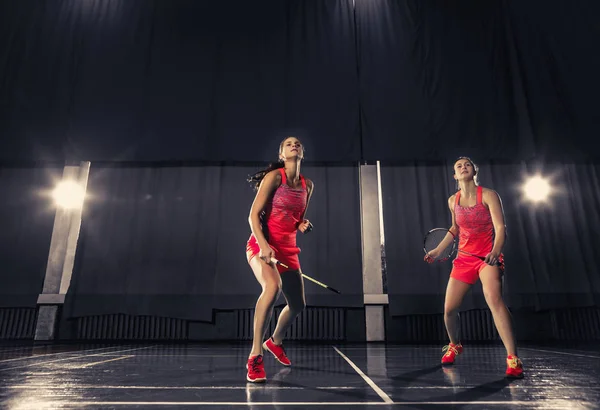 Unga kvinnor spelar badminton på gym — Stockfoto