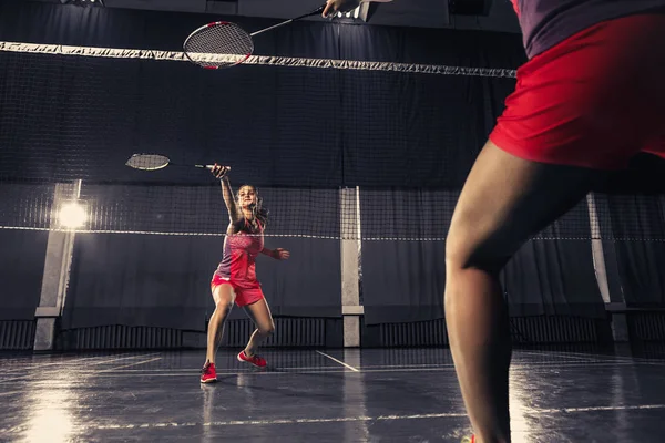 Genç kadın spor salonunda badminton oynarken