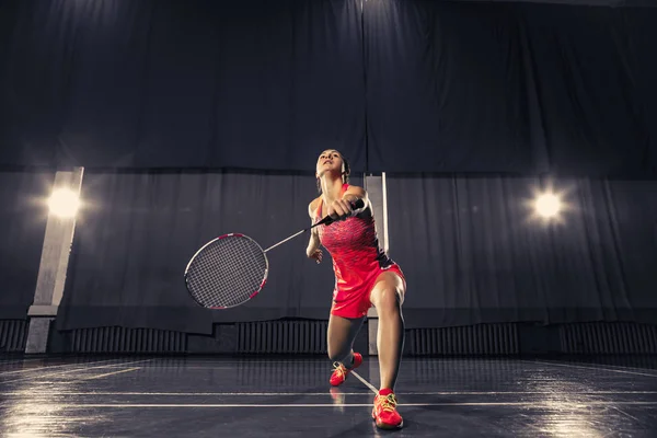 Ung kvinna spelar badminton på gym — Stockfoto