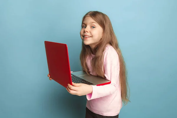El amor de la computadora. Chica adolescente con cuaderno sobre un fondo azul. Expresiones faciales y personas concepto de emociones — Foto de Stock