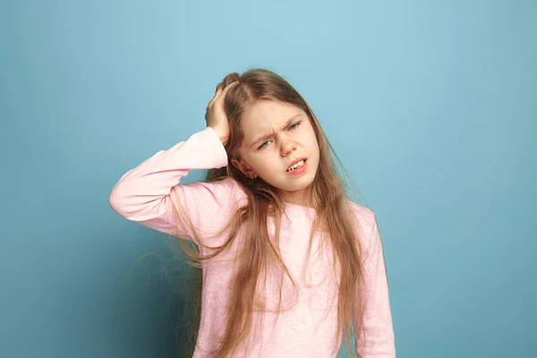 A dor de cabeça. Menina adolescente em um fundo azul. Expressões faciais e conceito de emoções de pessoas — Fotografia de Stock