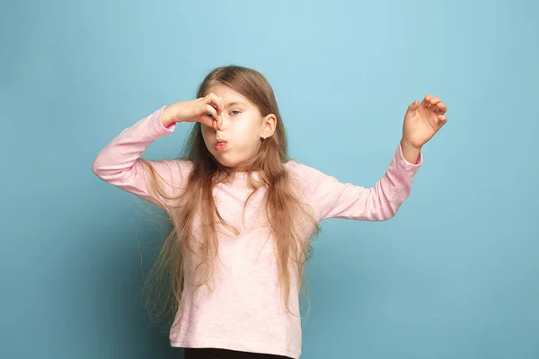 Avsky. Teen flicka på en blå bakgrund. Ansikts uttryck och människor känslor koncept — Stockfoto