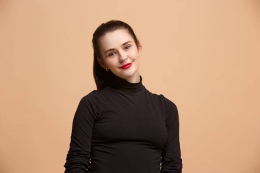Ayakta ve pastel arka planı gülümseyerek mutlu bir iş kadını.