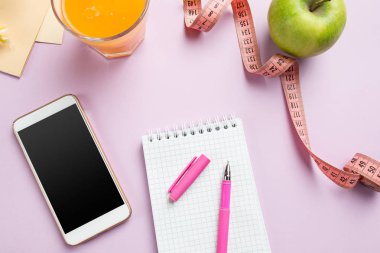 Üstten Görünüm yeşil elma, bant, cep telefonu, kalem ve açık defter ölçme. Fitness kavramı.
