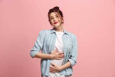 Ayakta ve pembe bir arka plan karşı gülümseyerek mutlu bir iş kadını.