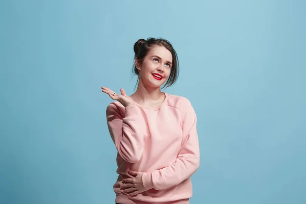 De gelukkige zakenvrouw permanent en glimlachend tegen blauwe achtergrond. — Stockfoto