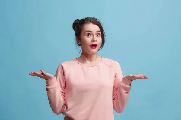 Portret van ontevreden jonge vrouw over blauw. Mooie vrouw kijken verbaasd — Stockfoto