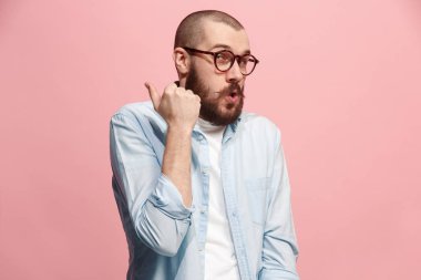 Pembe arka plan üzerinde elini arkasındaki sır fısıldayan genç adam