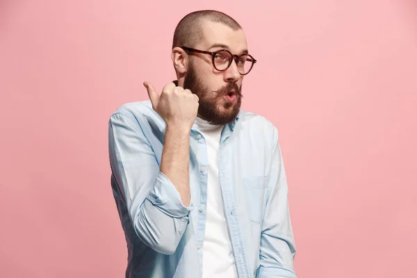 Der junge Mann flüstert ein Geheimnis hinter ihrer Hand über rosa Hintergrund — Stockfoto