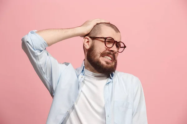 Uomo che ha mal di testa. isolato su sfondo rosa . — Foto Stock