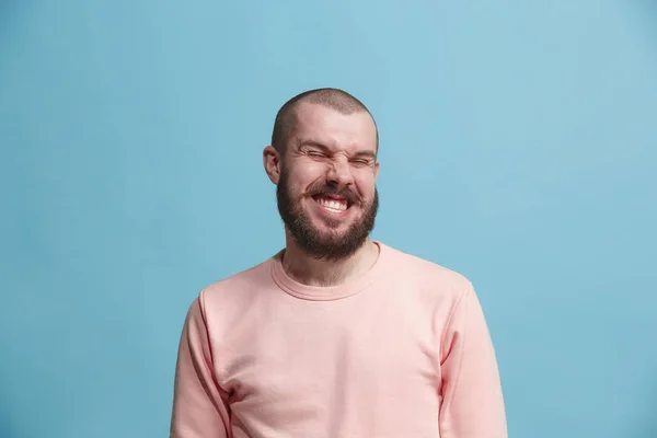 El hombre de negocios feliz de pie y sonriendo contra el fondo azul . — Foto de Stock