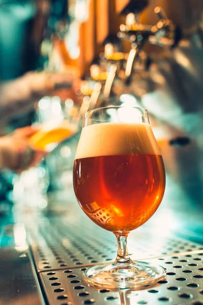 Ręka barman leje duże piwo lager w kran. — Zdjęcie stockowe