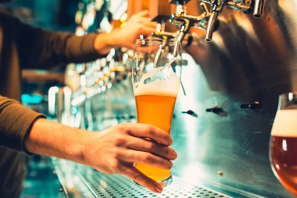 Mão do barman derramando uma grande cerveja lager na torneira . — Fotografia de Stock