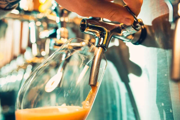 Mão do barman derramando uma grande cerveja lager na torneira . — Fotografia de Stock