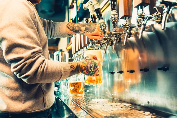 Mano de cantinero vertiendo una gran cerveza lager en el grifo . — Foto de Stock