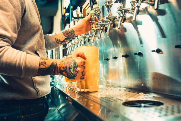 Mano de cantinero vertiendo una gran cerveza lager en el grifo . — Foto de Stock