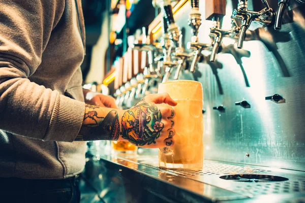 Mano de cantinero vertiendo una gran cerveza lager en el grifo . — Foto de Stock