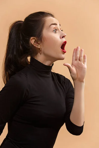 Isolé sur pastel jeune femme décontractée criant au studio — Photo