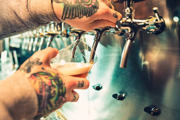 Mano de cantinero vertiendo una gran cerveza lager en el grifo . — Foto de Stock