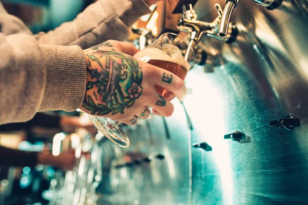 Mão do barman derramando uma grande cerveja lager na torneira . — Fotografia de Stock