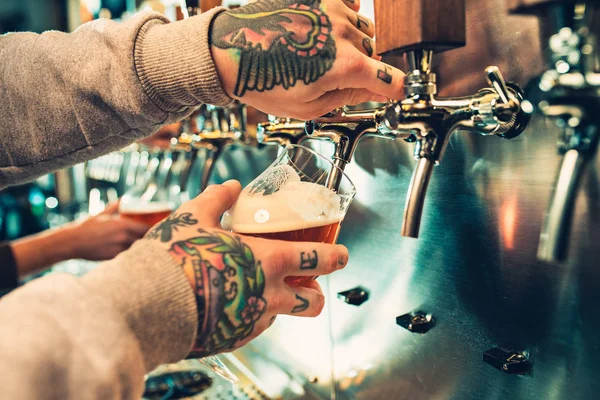 Hand van barman gieten een grote pils in kraan. — Stockfoto