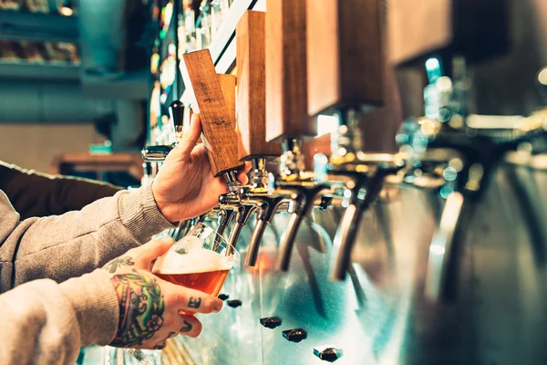 Hand van barman gieten een grote pils in kraan. — Stockfoto