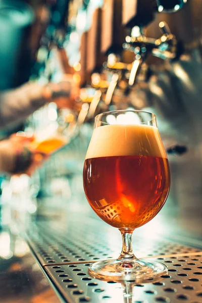 Hand des Barkeepers gießt ein großes Pils in den Zapfhahn. — Stockfoto