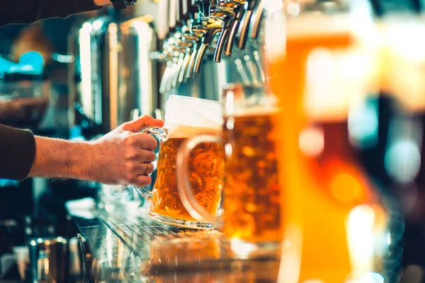 Mão do barman derramando uma grande cerveja lager na torneira . — Fotografia de Stock