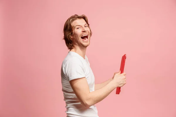 O homem de negócios feliz com o computador portátil vermelho no rosa — Fotografia de Stock