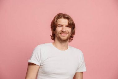 Ayakta ve pembe bir arka plan karşı gülümseyen mutlu iş adamı.