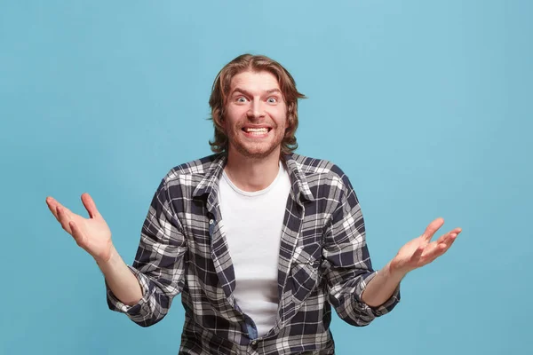 Hermoso hombre mirando sorprendido aislado en azul —  Fotos de Stock