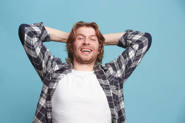 O homem de negócios feliz de pé e sorrindo contra o fundo azul . — Fotografia de Stock