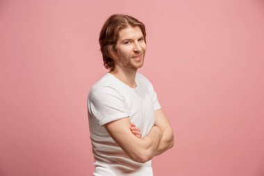 Ayakta ve pembe bir arka plan karşı gülümseyen mutlu iş adamı.