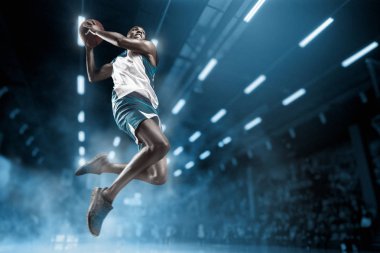 Basketball player on big professional arena during the game. Basketball player making slam dunk. clipart