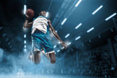 Basketball player on big professional arena during the game. Basketball player making slam dunk. clipart