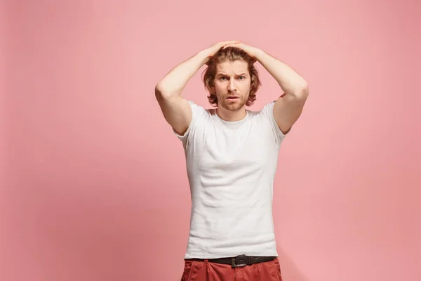 Schöner Mann sieht überrascht und verwirrt isoliert auf rosa — Stockfoto