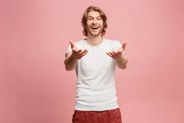 El hombre de negocios feliz de pie y sonriendo sobre el fondo rosa . — Foto de Stock