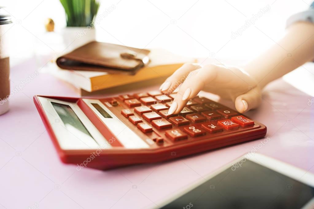 woman is holding purse, credit card in hands and calculating the costs