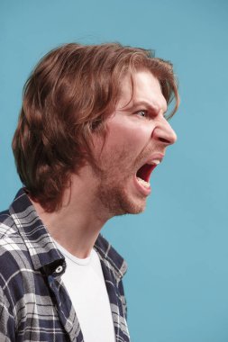 Mavi stüdyo arka planda çığlık genç duygusal kızgın adam