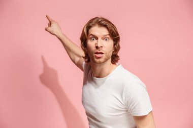 Pembe studio backgroud izole güzel erkek varoluş portre. Genç duygusal şaşırmış adam
