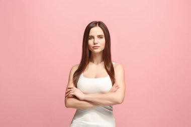 Ayakta ve pembe bir arka plan karşı gülümseyerek mutlu bir iş kadını.